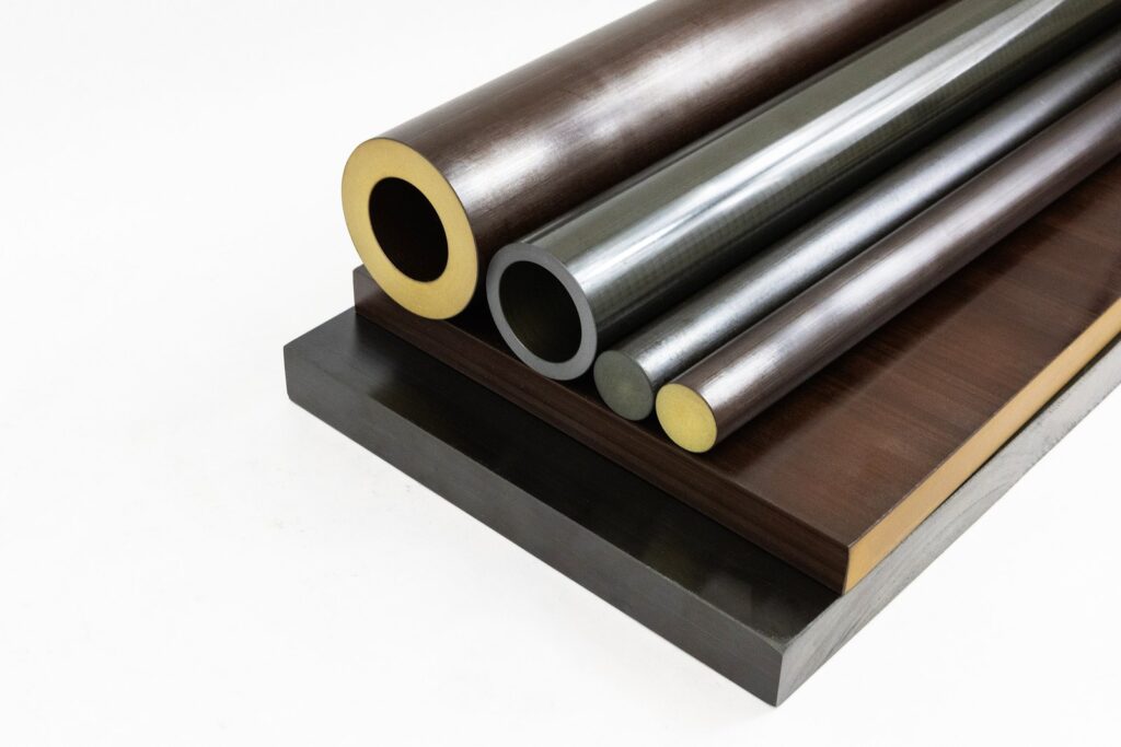 Torlon Seamless Tube와 Torlon 봉 및 Plate 재고 형태가 나란히 전시되어 있습니다.